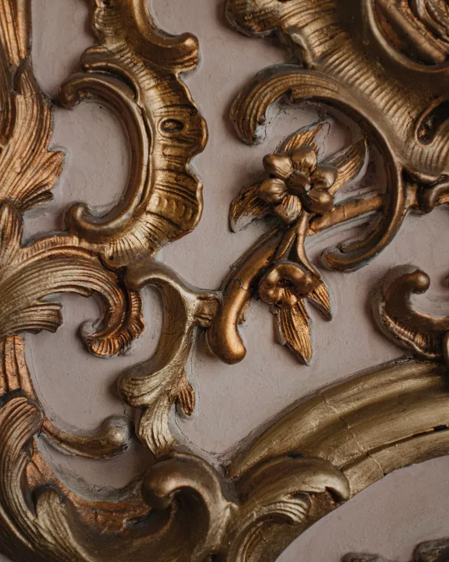 Detalle de una talla dorada con desgastes que dejan ver el bol y la preparación bajo la hoja de oro